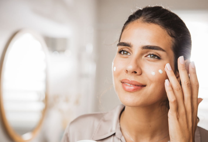 Mulher montando uma rotina de cuidados com a pele usando produtos de skincare
